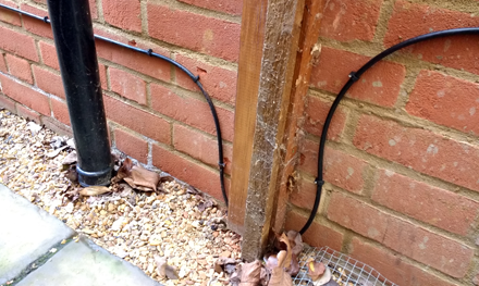external cat5e ethernet cabling installed along wall of house under gate in house in hertfordshire