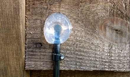 external cat5e ethernet cable going through hole in wood on side of summerhouse and sealed with silicon sealant in hitchin hertfordshire