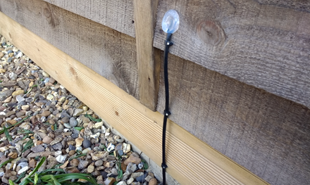 external cat5e ethernet cable going through hole in wood on side of shed and sealed with silicon sealant