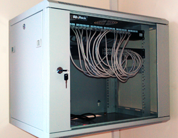 allrack data cabinet on wall in stevenage pcb manufacturer with 24 way connectix patch panel termination of 24 cat5e ethernet network cables for computer network